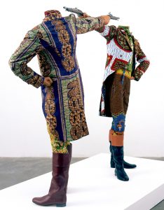 Photographie d'une oeuvre de l'expo IncarNations (BOZAR, 2019): Yinka Shonibare CBE, How to blow up two heads at once, Installation, 2 mannequins, wax allemand imprimé en coton, bottes en cuir, socle, 2006, 175 x 245 x 122 cm © Yinka Shonibare, courtesy of Stephen Friedman Fine Art